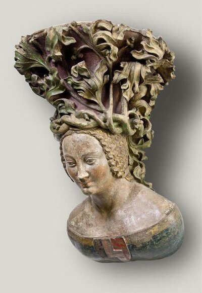 Weibliche Büste mit einem Wappen auf der Brust und einem Kopfschmuck aus geflochtenen Reben