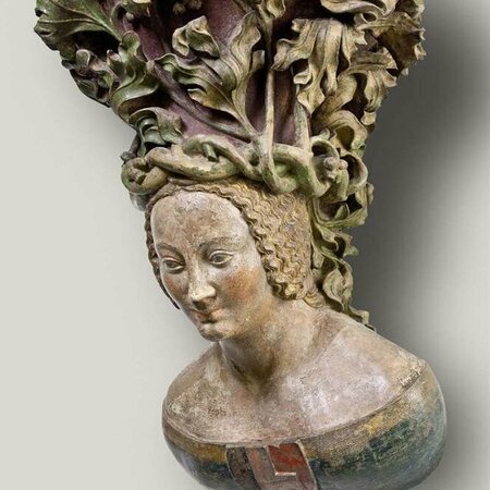 Weibliche Büste mit einem Wappen auf der Brust und einem Kopfschmuck aus geflochtenen Reben