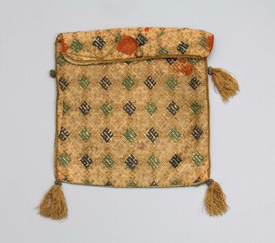 Goldfarbener Leinenbeutel mit Stickereien.