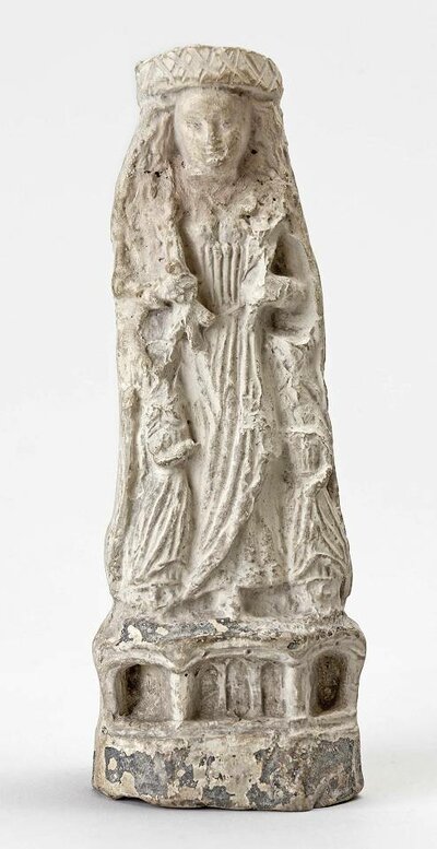 Tonstatue einer langhaarigen, stehenden Frau. Details sind aufgrund des Zustands der Statue schwer zu erkennen.