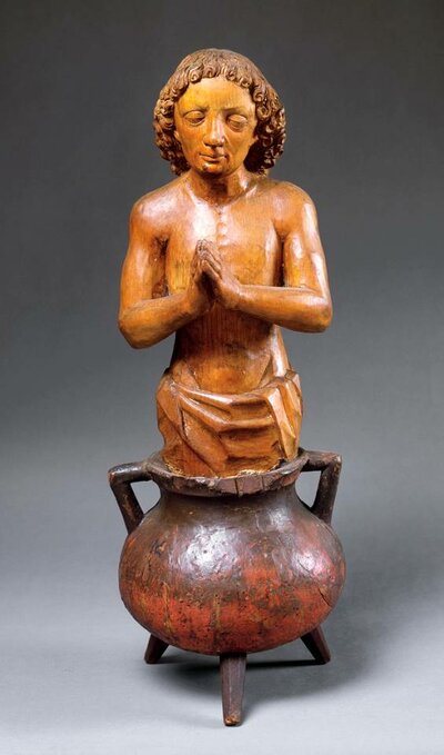 Holzfigur eines betenden Mannes, der in einem Dreifuß-Kessel kniet.