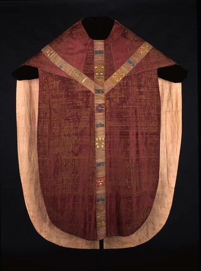 Rot- beige Kasel mit Stickereien in Kreuzform auf der Vorderseite.