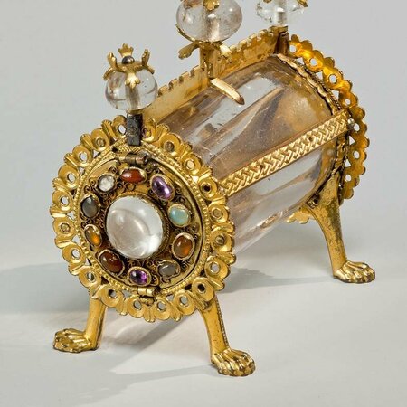 Zylinderförmiger Behälter, der auf vier vergoldeten Pfoten steht. Die Mitte ist aus eingefasstem Bergkristall.