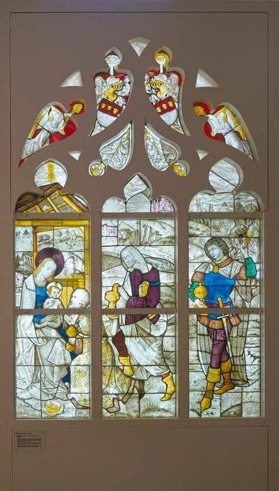 Kirchenfenster auf dem Maria mit dem Jesuskind auf ihrem Schoß zusammen mit den heiligen drei Königen abgebildet ist.