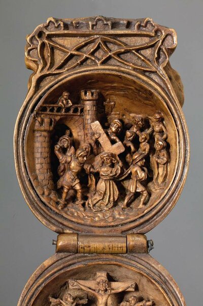 Aufgeklappte Gebetsnuss aus Holz. Im Inneren ist der Kreuzzug abgebildet.