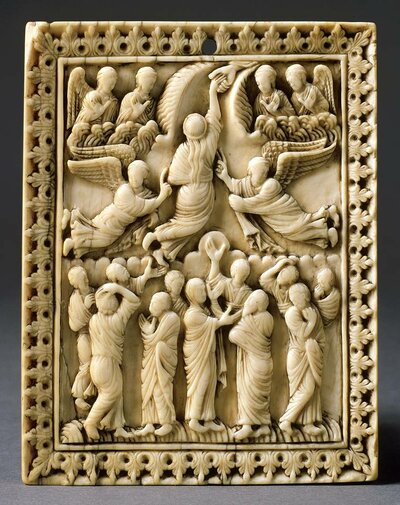 Im Zentrum der Tafel aus Elfenbei steht Jesus, der über einer Menschenansammlung zu schweben scheint. Seine Hand liegt ausgestreckt in einer Hand, die vom Himmel kommt.