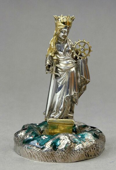 Silberne Figur einer stehenden Frau. In der rechten Hand hält sie ein Schwert, in der linken ein Ruder. Auf dem Kopf trägt sie eine vergoldete Krone.
