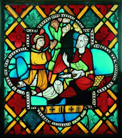 Glasmalerei, die rechts einen alten Mann mit Schwert im Schoß zeigt. Links von ihm kniet ein junger Mann und betet.