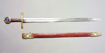 Schwert mit filigran verzierter Scheide. Der Knauf des Schwertes ist mit der Abbildung eines Schmetterlings verziert.