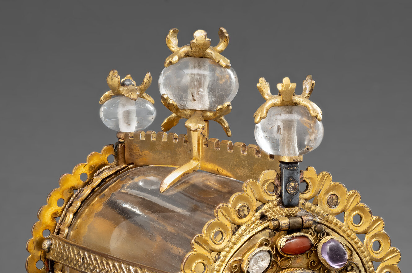 Zylinderförmiger Behälter, der auf vier vergoldeten Pfoten steht. Die Mitte ist aus eingefasstem Bergkristall.