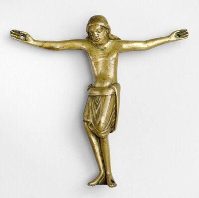 Jesusfigur eines Kruzifixes aus Bronze. In Händen und Füßen sind Löcher.