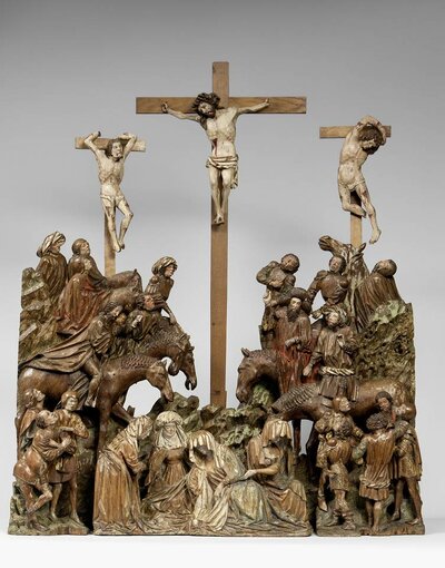 Holzschnitzerei der Kreuzigung Jesu. Im Vordergrund Jesus am Kreuz. An seiner Seite jeweils ein weiterer gekreuzigter Mann. Die Kreuze ragen über eine Menschenansammlung.