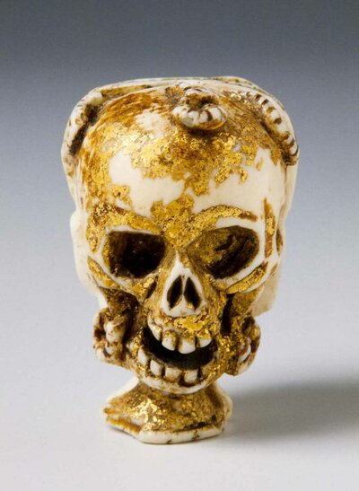 Aus Elfenbein gefertigter menschlicher Schädel. An ihm befinden sich Goldreste.