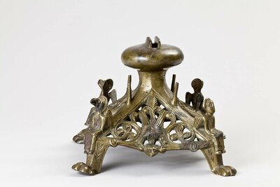 Kreuzfuß mit vier geflügelten Figuren, die an den Füßen sitzen.