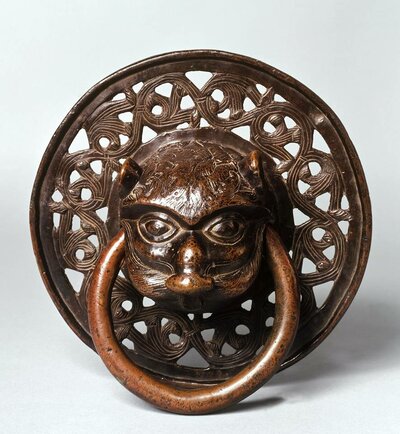 Löwenkopf aus Bronze, der einen Bronzering im Maul hält.