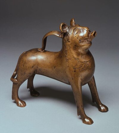 Löwenfigur aus Bronze. Auf seinem Rücken ist eine Art Griff angebracht. Aus seinem Maul ragt ein kurzes Rohr.