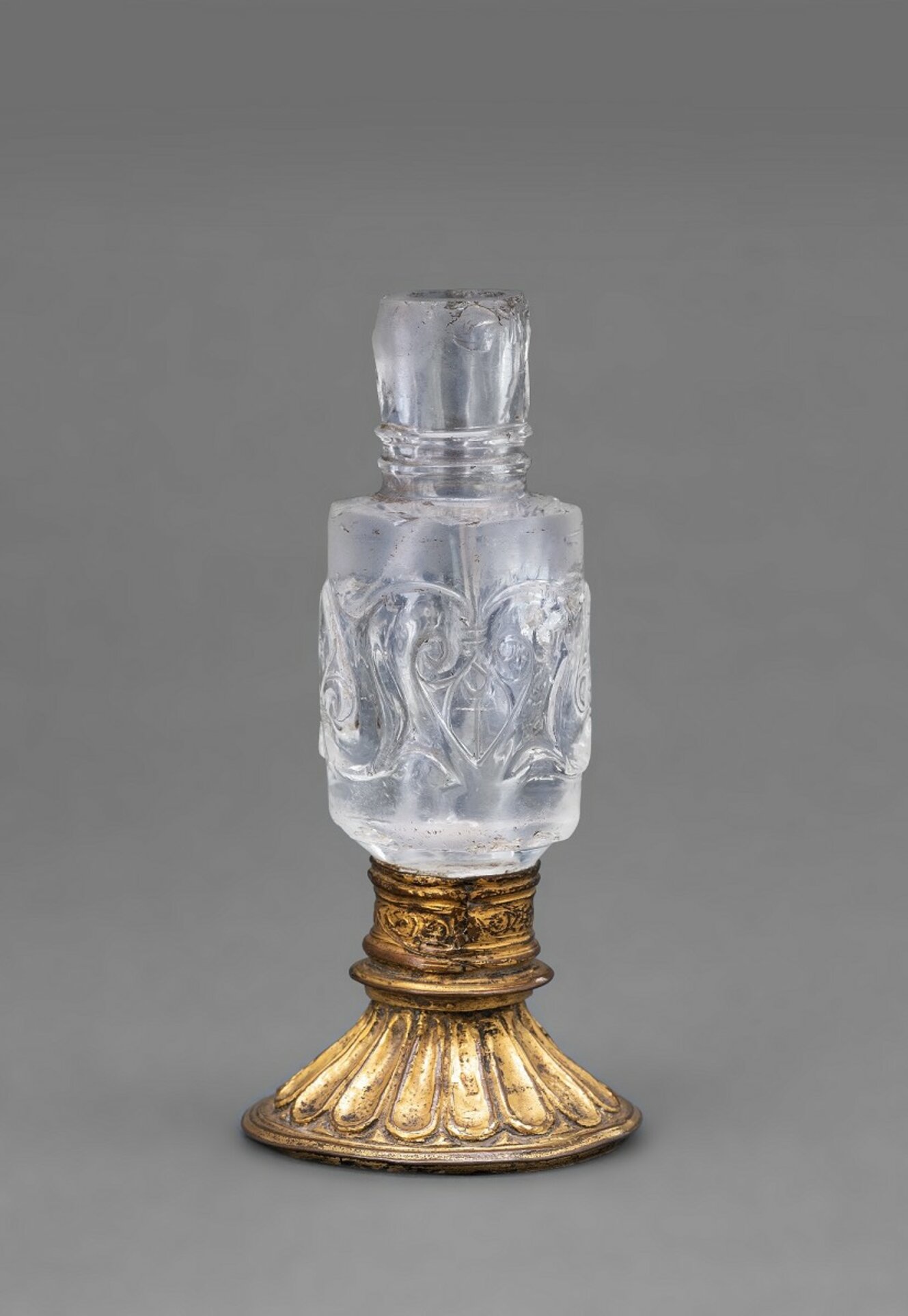 Gefäß aus geschliffenen Bergkristall mit einem goldfarbenem Fuß.