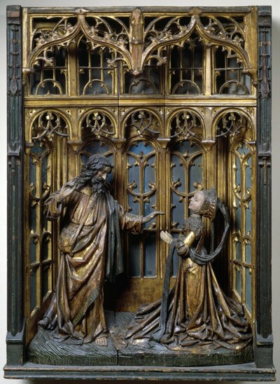 Holzschnitzerei von Jesus und Maria Magdalena unter detailreichen Ornamenten.