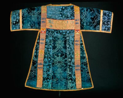 Gewand mit goldnen Borten und blauen Verzierungen aus Samt.