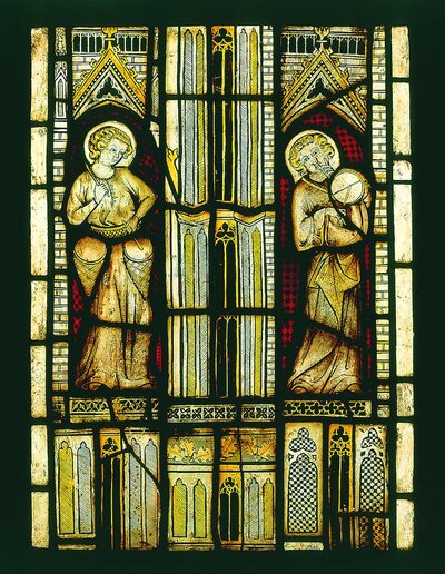 Die Glasmalerei zeigt zwei Engel. Einer hat zwei Trommeln auf hüfthöhe. Der andere spielt auf einer Flöte und auf einer Trommel über seiner Schulter.