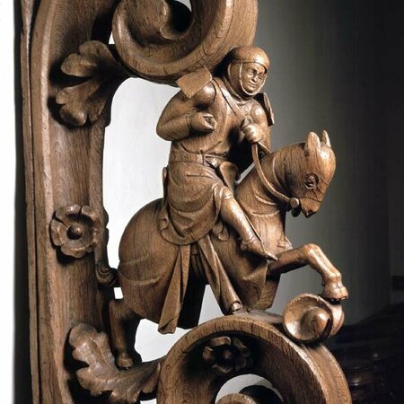 Ein aus Holz geschnitzter Ritte sitzt auf einem ebenfalls geschnitztem Pferd.