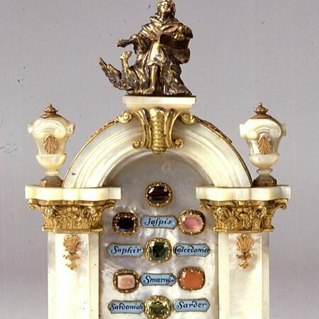 Barock anmutendes Miniaturtor aus Permutt mit bronzener Verzierung und in der Mitte verschiedenen geschliffenen Edelsteinen mit blauen Schildern zur Bezeichnung darunter