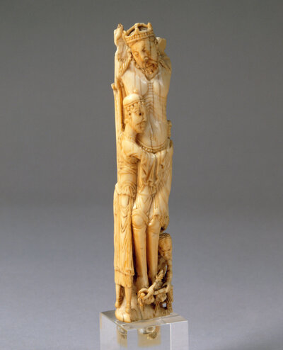 Figur eines Mannes. Dieser hat die Arme um die Hüfte eines weiteren Mannes mit Krone und geschlossenen Augen gelegt. 