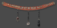 Gürtel aus rotem Stoff mit Goldfäden durchwirkt und mit Münzen besetzt. Daran hängen drei Gliederketten mit geschitzten schwarzen Perlen und einem Totenschädel aus Bergkristall.