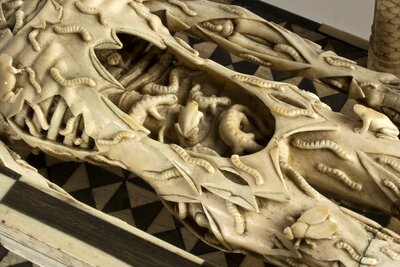 Ausschnitt des menschlichen Skeletts aus Elfenbein. In der Bauchhöhle sitzen eine Kröte, eine Schnlange sowie zwei salamander-artige Tiere.