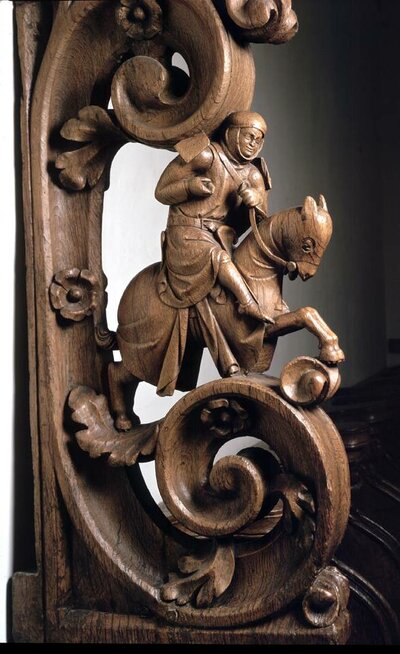 Ein aus Holz geschnitzter Ritte sitzt auf einem ebenfalls geschnitztem Pferd.