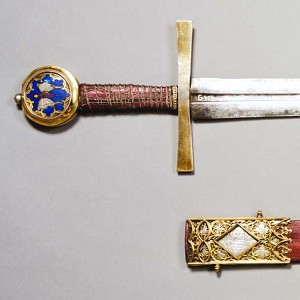  Schwert aus St. Georg in Köln mit zugehöriger Scheide, Köln, 1. H. 14. Jh., Klinge: Italien, 14. Jh. (?), Stahlklinge, vergoldetes Silber mit Silberemail, Leder, Holz, 105 x 17,5 x 2,4 cm (Scheide 85,5 x 8 x 1,8 cm), Inv. G 494 a, b, © Rheinisches Bildarchiv 
   